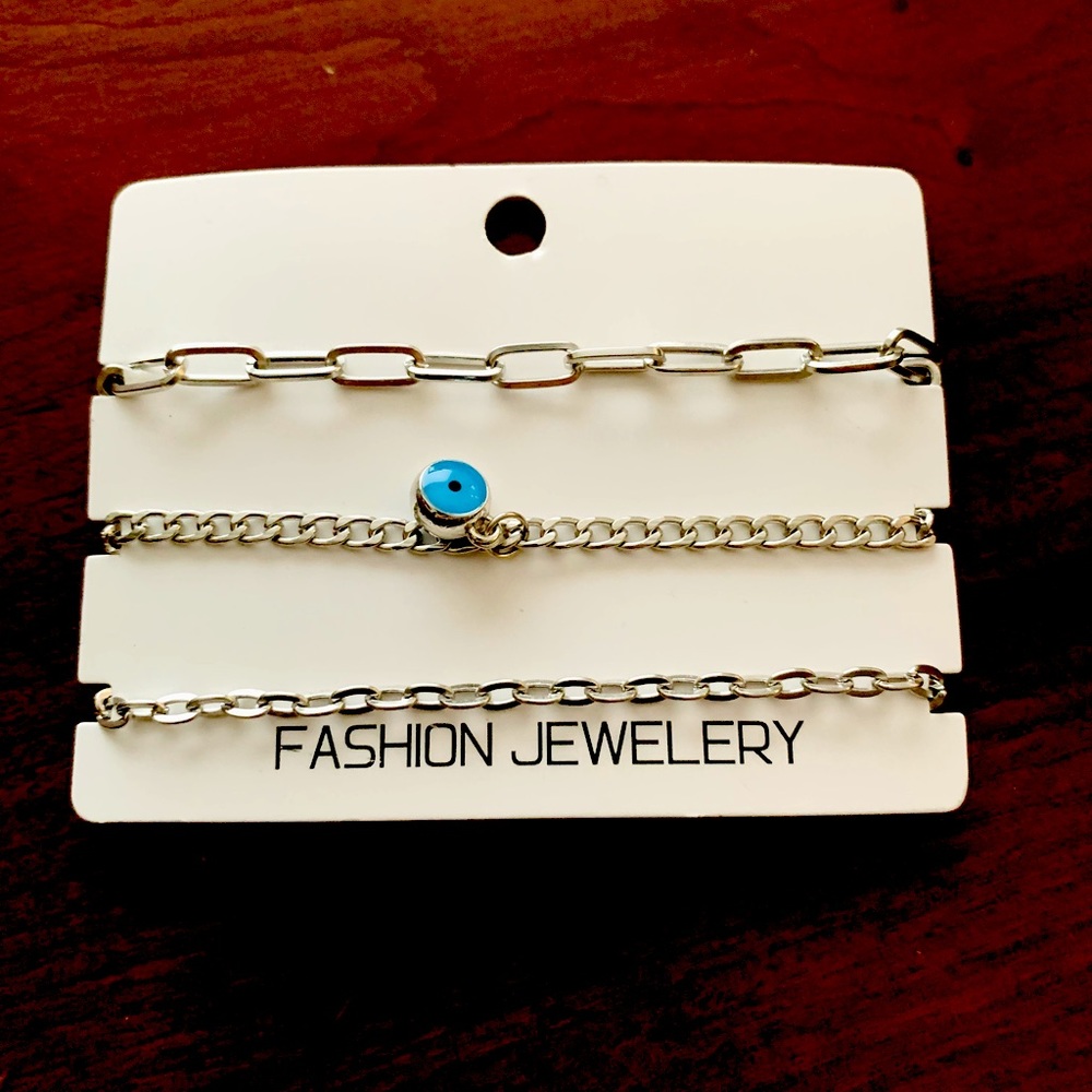 Set of 3 silver tone metal chain bracelets with blue evil eye